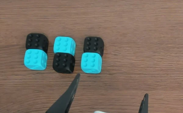 Photograph of six dice on a table, all showing six pips on the upward face.